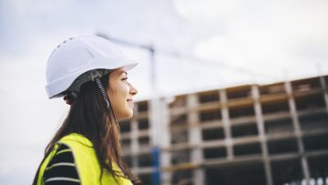 Une femme sur un chantier avec un sourire aux lèvres